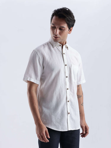 Man wearing a white short-sleeve shirt against a plain background