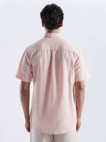 Back view of a man wearing a blushy peach linen shirt from Turms Intelligent Apparel, showcasing its stylish design and quality fabric.