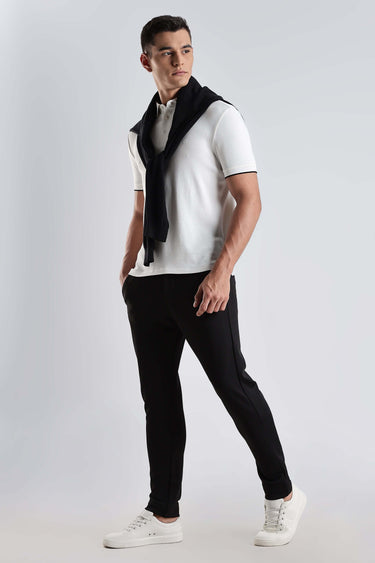 White Owl cotton polo tshirt model wearing premium stylish outfit with black pants and sneakers.