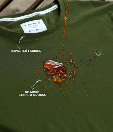 Turms green round-neck Polo T-shirt with water-resistant and anti-stain technology, showing liquid spill resistance and premium fabric.