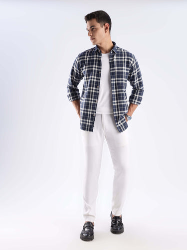 Model wearing the Turms recycled cotton checked shirt with white pants, showcasing sustainable fashion and stylish comfort.