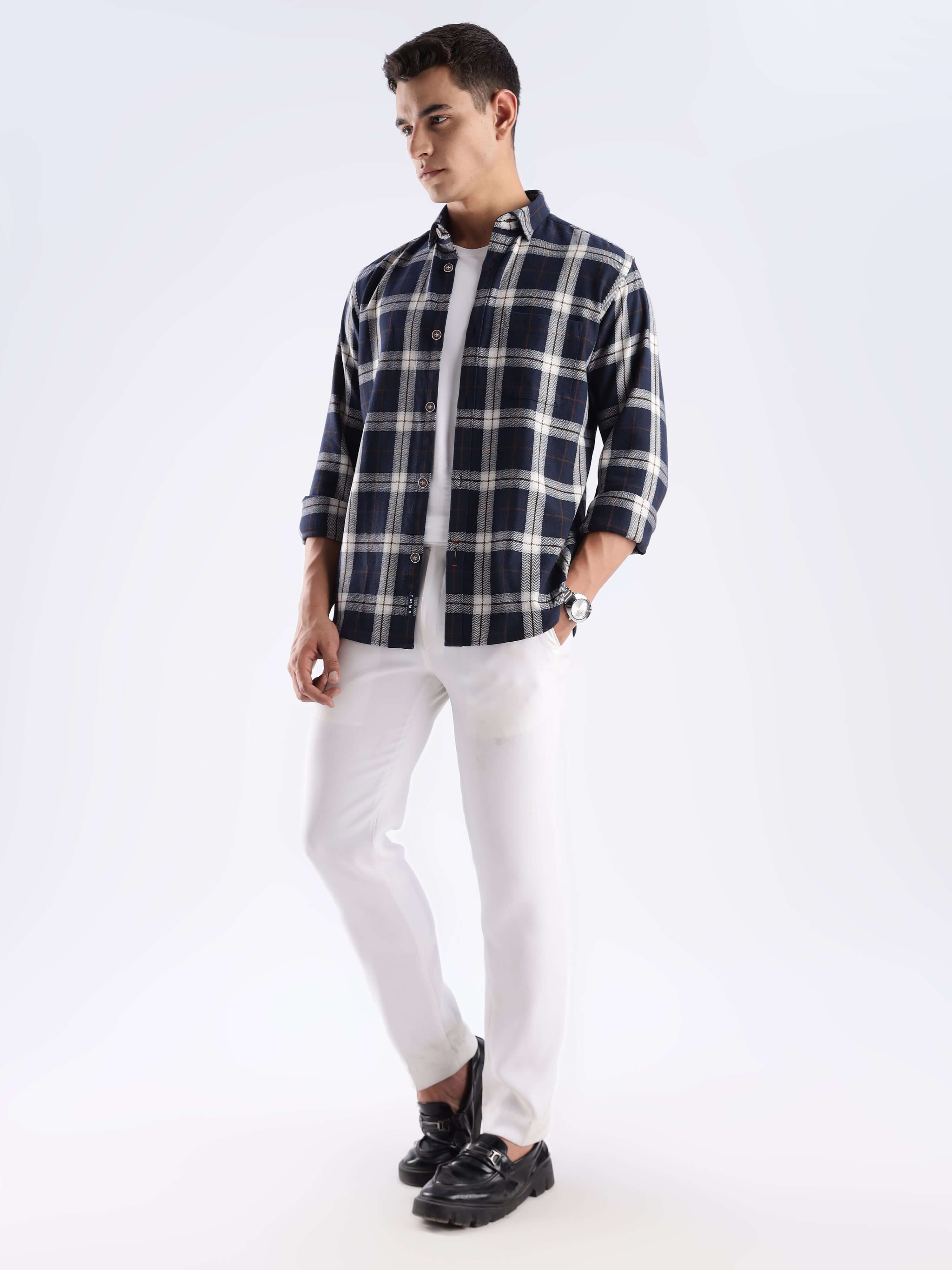 Man wearing a blue and white checked recycled cotton shirt, styled with white pants and black shoes.