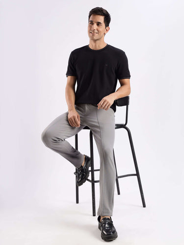 Man wearing a black knitted shirt with 8-way stretch and grey pants, showcasing comfort and style.