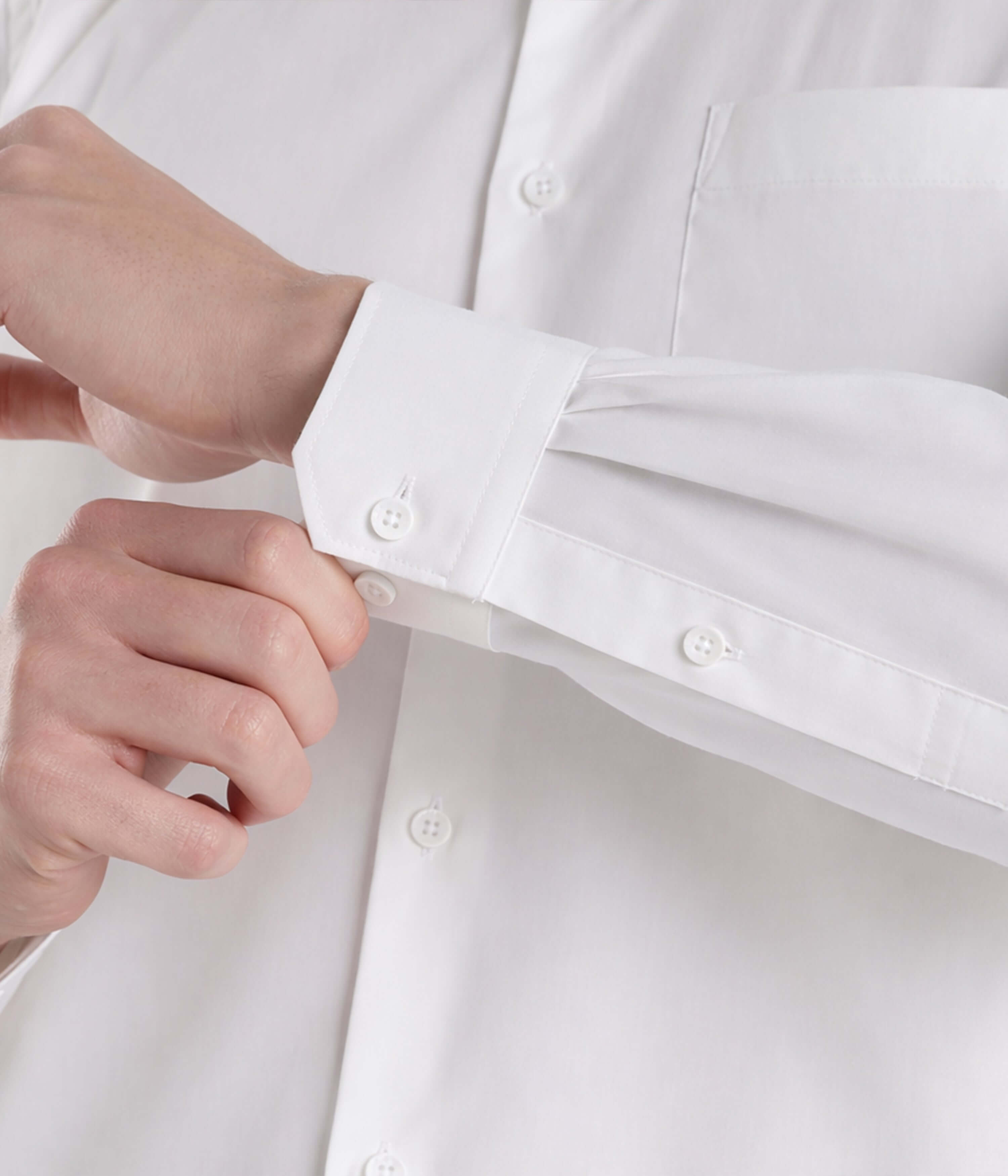 Person adjusting the cuff of the Elite White cotton Giza shirt, showcasing premium craftsmanship and style.