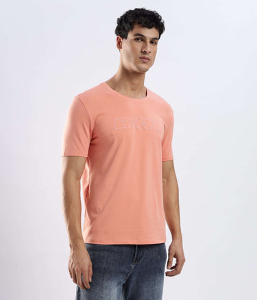 Model wearing Ember Orange cotton tshirt, showcasing its stretchable, waterproof, and anti-odour features.