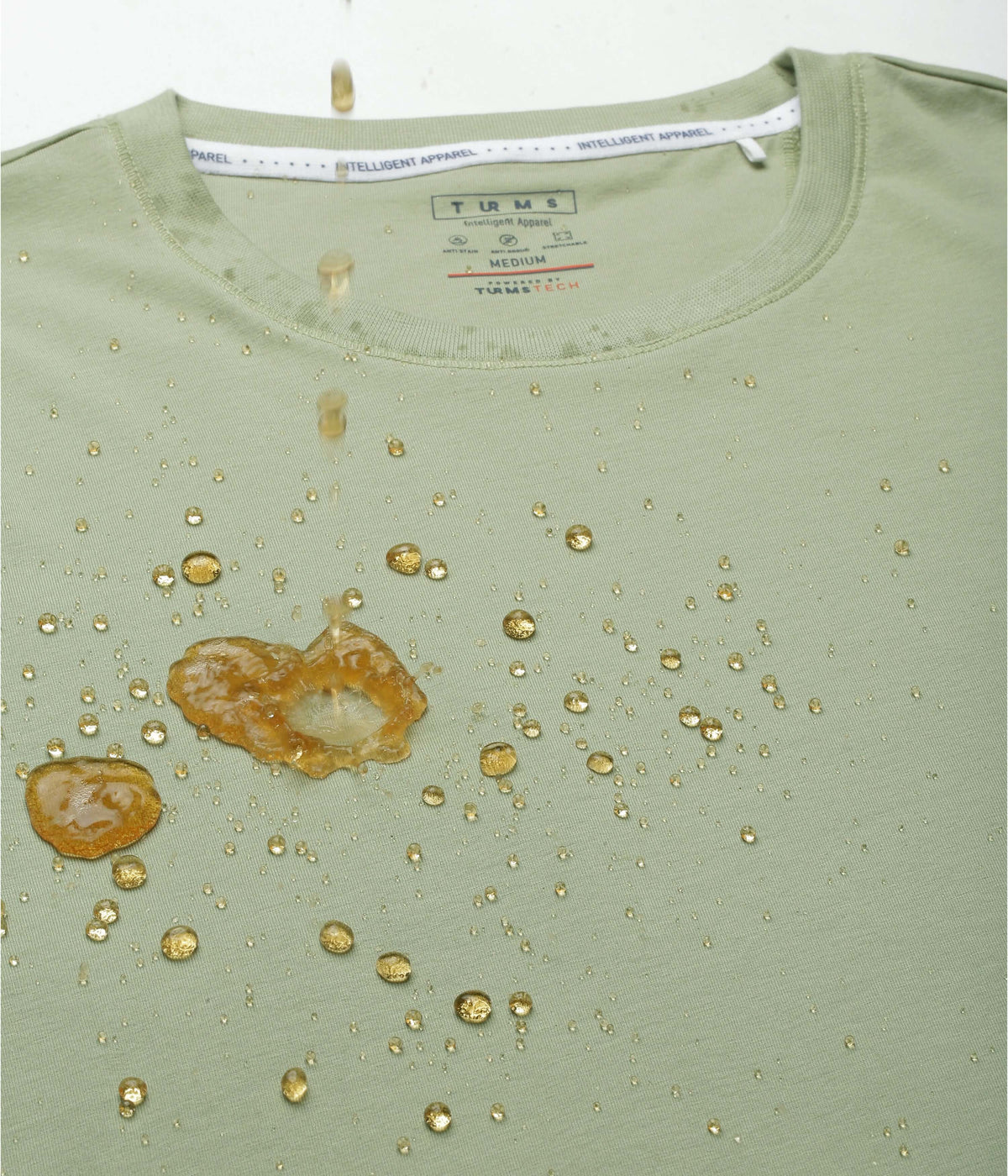 Citrus lime Turms Intelligent Apparel men's t-shirt showing water-resistant features with droplets on fabric.