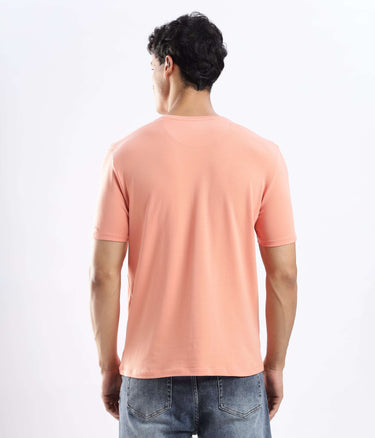 Back view of a man wearing the Ember Orange cotton t-shirt, showcasing its stretchable and durable design.