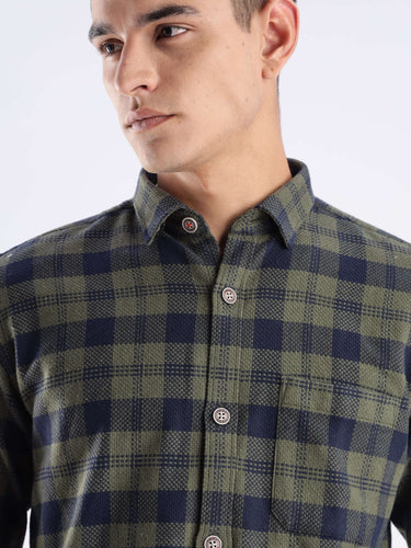 Man wearing a recycled cotton checked shirt from Turms, showcasing sustainable fashion with a cool tech feature.