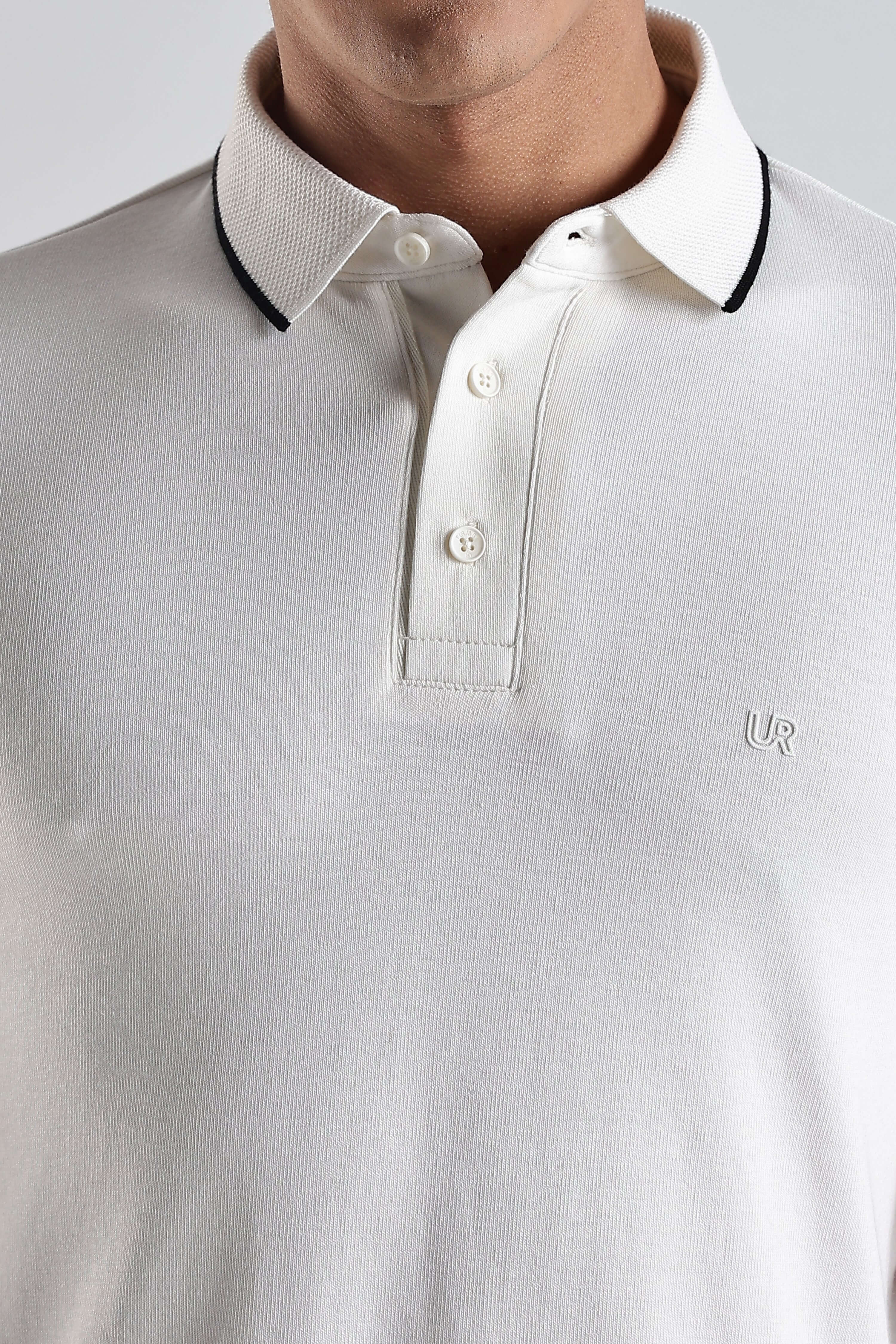 Close-up of a man wearing the White Owl premium cotton polo tshirt with a stylish collar.