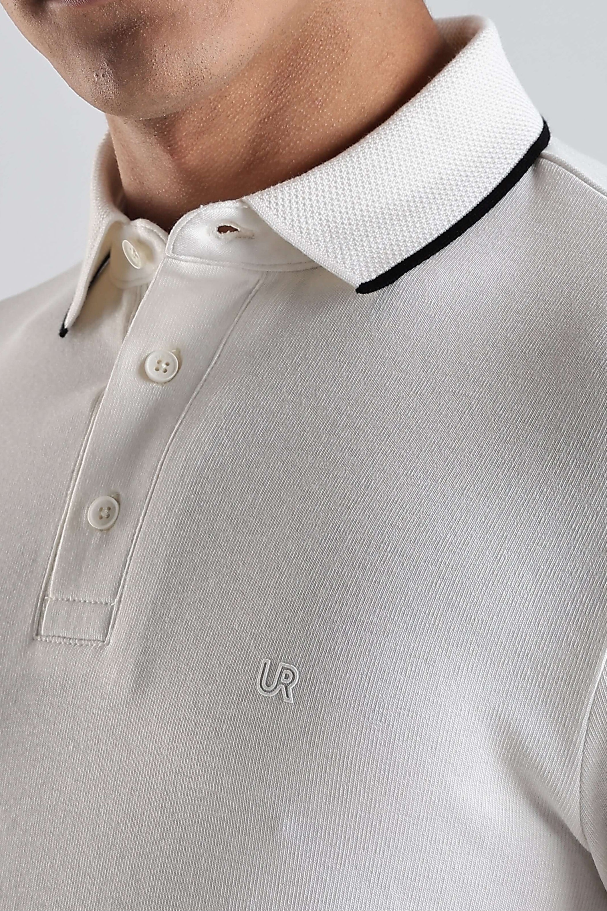 Close-up of a man wearing a White Owl premium cotton polo t-shirt featuring a stylish collar and buttons.