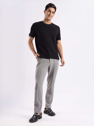 Man wearing a black Turms Intelligent Ice Cool Tech T-Shirt with stylish gray pants, showcasing premium comfort and innovative features.