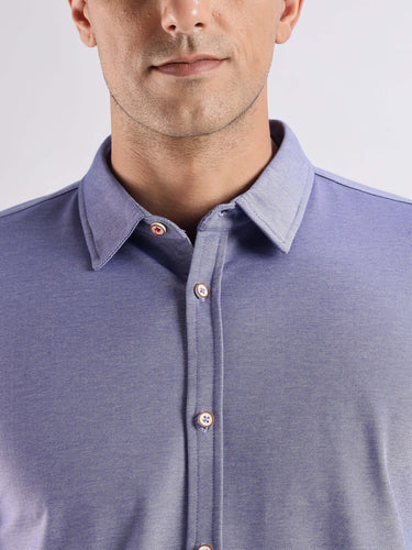 Close-up of a man in a blue knitted shirt, showcasing premium cotton, 8-way stretch, and stylish design.