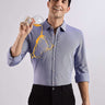 Man wearing a blue knitted shirt, showcasing its anti-stain feature with spilled drink, highlighting premium quality.