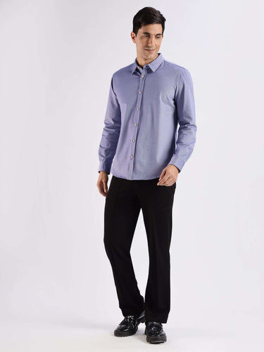 Man wearing a blue knitted shirt with 8-way stretch, featuring anti-odour and anti-stain properties from Turms.
