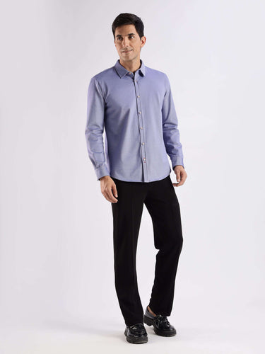 Man wearing a blue knitted shirt with 8-way stretch, anti-odour, and anti-stain features from Turms.