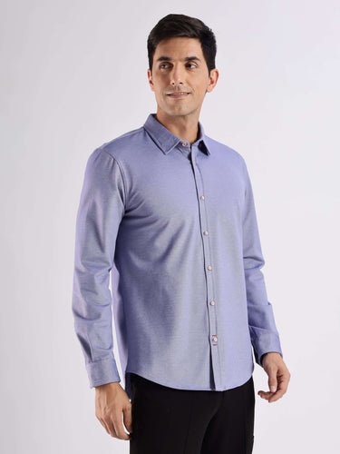 Model wearing a blue knitted shirt with advanced 8-way stretch, anti-odour, and stain-resistant features.