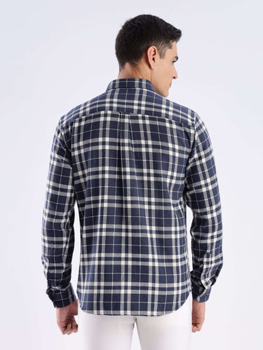 Back view of a man wearing a sustainable recycled cotton checked shirt from Turms in navy and white.