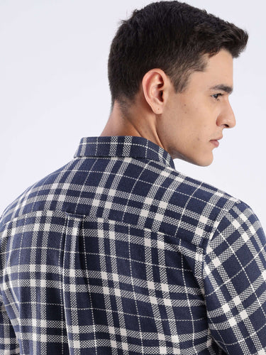 Back view of a model wearing the Turms recycled cotton checked shirt in navy and white, showcasing its stylish design.