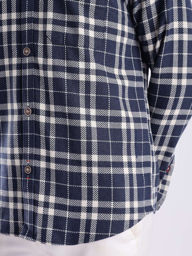 Close-up of a navy and white checked shirt made from recycled cotton, showcasing its sleek design and durable fabric.