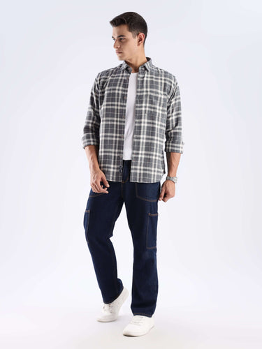 Man wearing a sustainable Turms recycled cotton check shirt with cool tech features and stylish jeans.