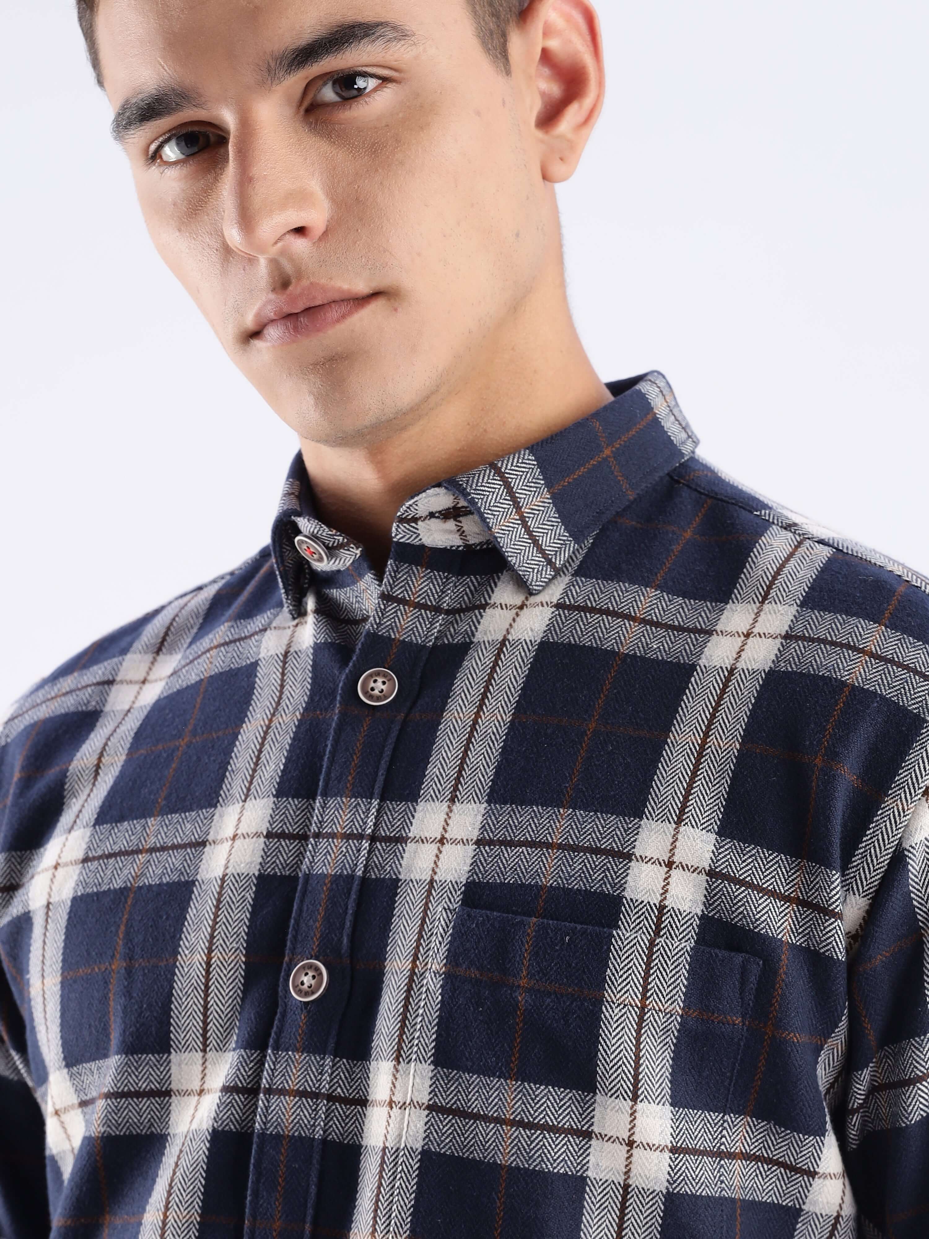Close-up of a man wearing a stylish blue and white checked shirt made from recycled cotton, showcasing sustainable fashion.