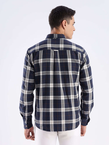 Back view of a man wearing a blue and plaid recycled cotton shirt, showcasing sustainable fashion and durability.