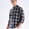 Stylish man wearing a blue checked shirt made from recycled cotton, showcasing sustainable fashion with anti-odour technology.