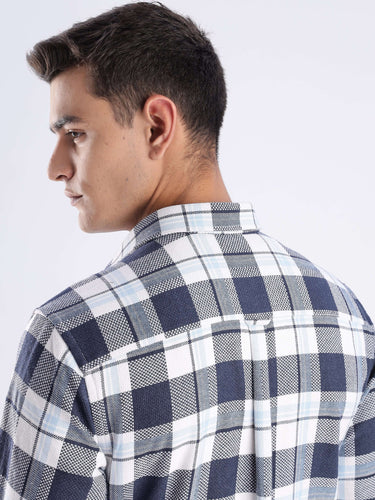 Back view of a man wearing a blue checked recycled cotton shirt, showcasing style and sustainability.