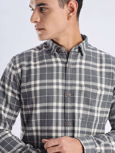 Man modeling a stylish recycled cotton checked shirt by Turms, showcasing sustainable fashion and cool tech features.