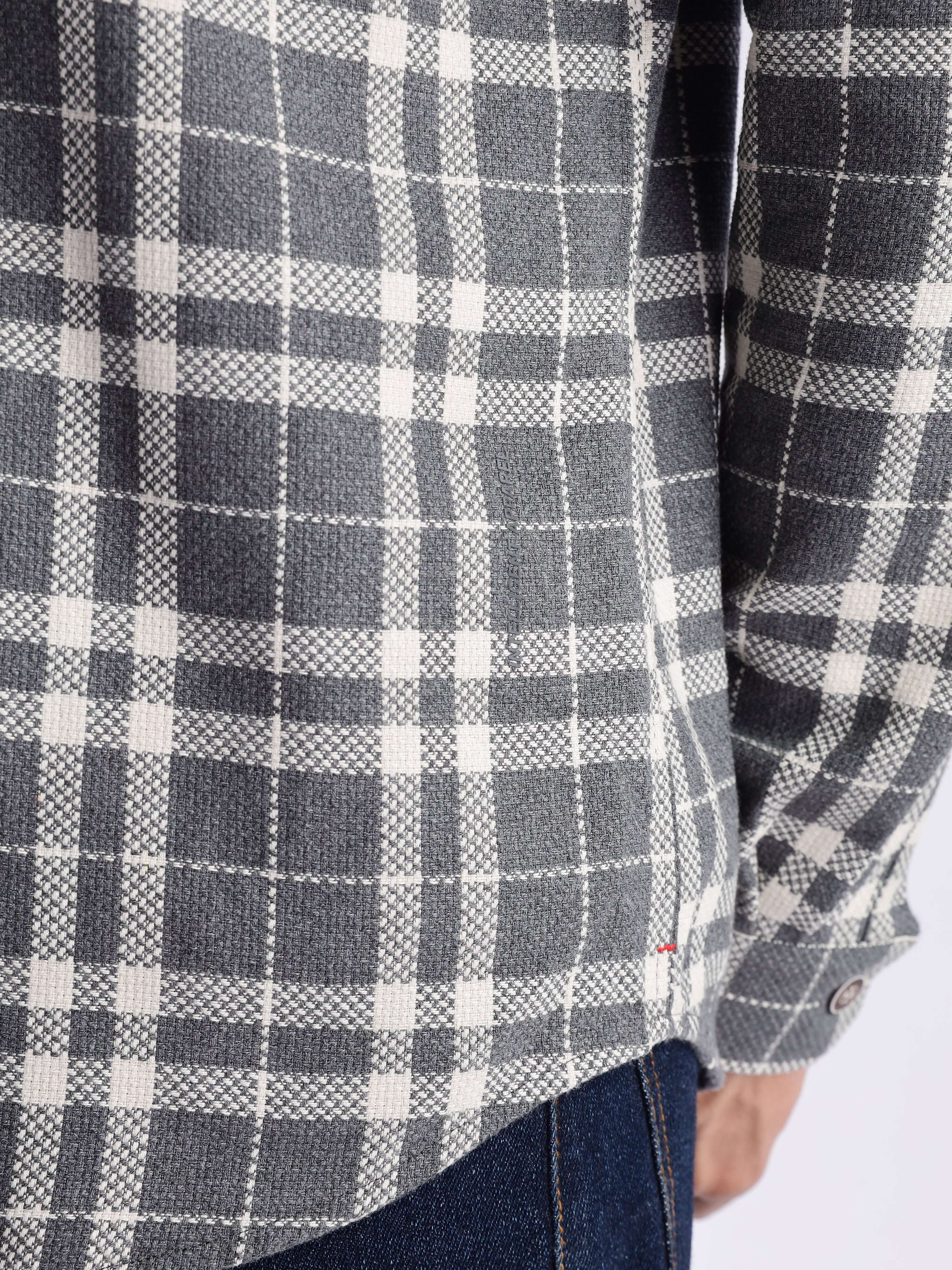Close-up of a stylish check shirt made from recycled cotton, showcasing its durability and modern design features.