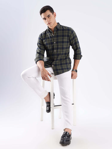 Model wearing a stylish olive and navy checked shirt with white jeans, showcasing sustainable fashion with a modern twist.