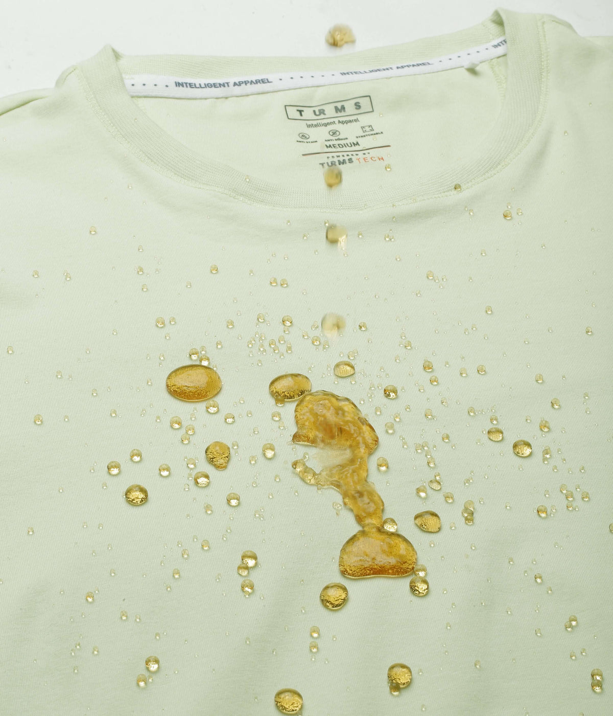 Mint Green Turms Intelligent Apparel T-Shirt with water-resistant feature, showcasing drops and spills on fabric.