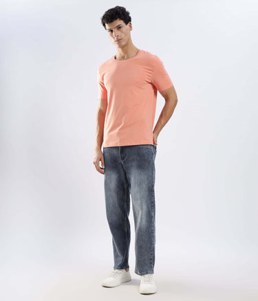 Man wearing Ember Orange Turms Worry-Free Intelligent T-Shirt with jeans, showcasing style and comfort.