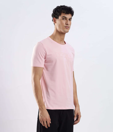 Man wearing a stretchable Quartz Pink cotton tshirt, featuring a sleek design and comfortable fit.