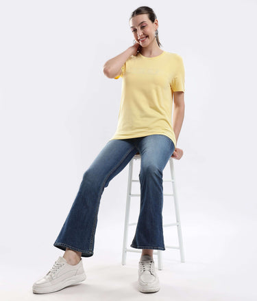 Model wearing Womens casual t-shirt Aura Yellow cotton tshirt with comfortable stretchable denim jeans.