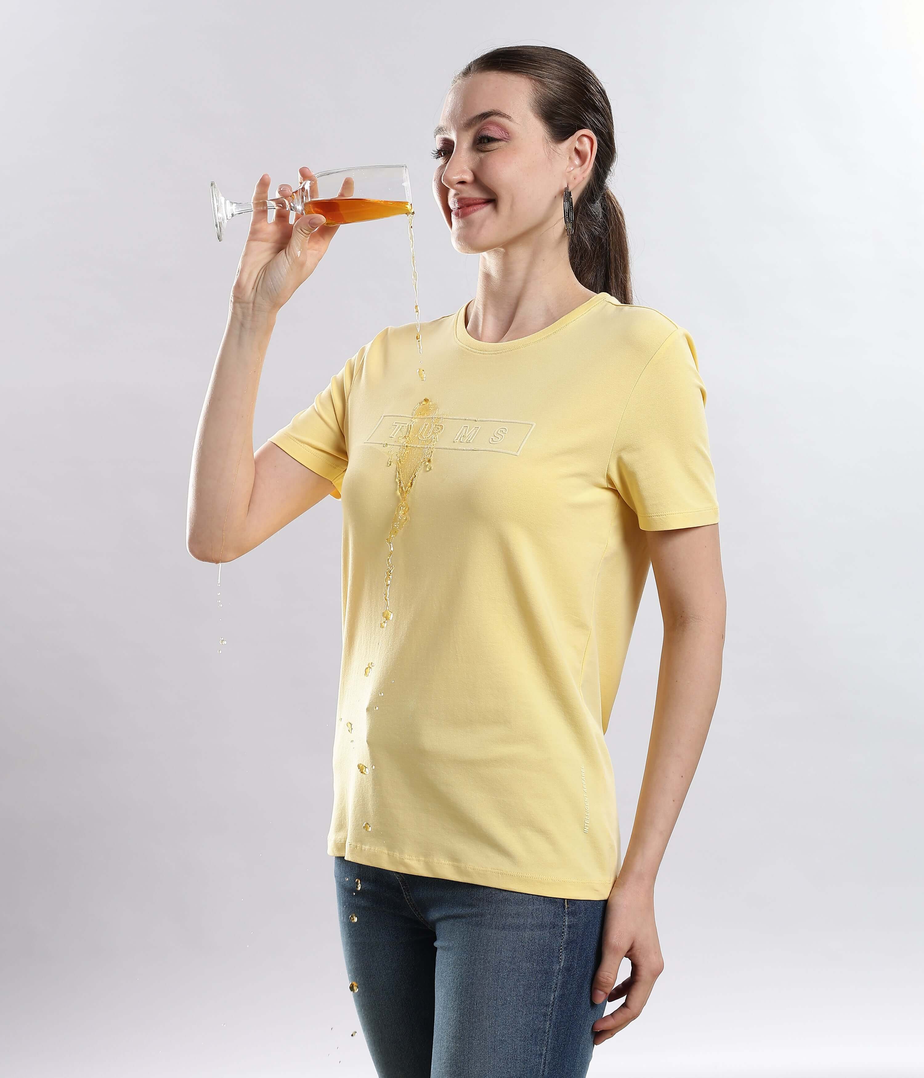 Woman wearing Womens casual t-shirt Aura Yellow cotton tshirt, demonstrating its waterproof feature while enjoying a drink.