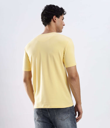 Back view of a man wearing the Aura Yellow cotton tshirt, showcasing its stretchable, waterproof, and anti-odour features.