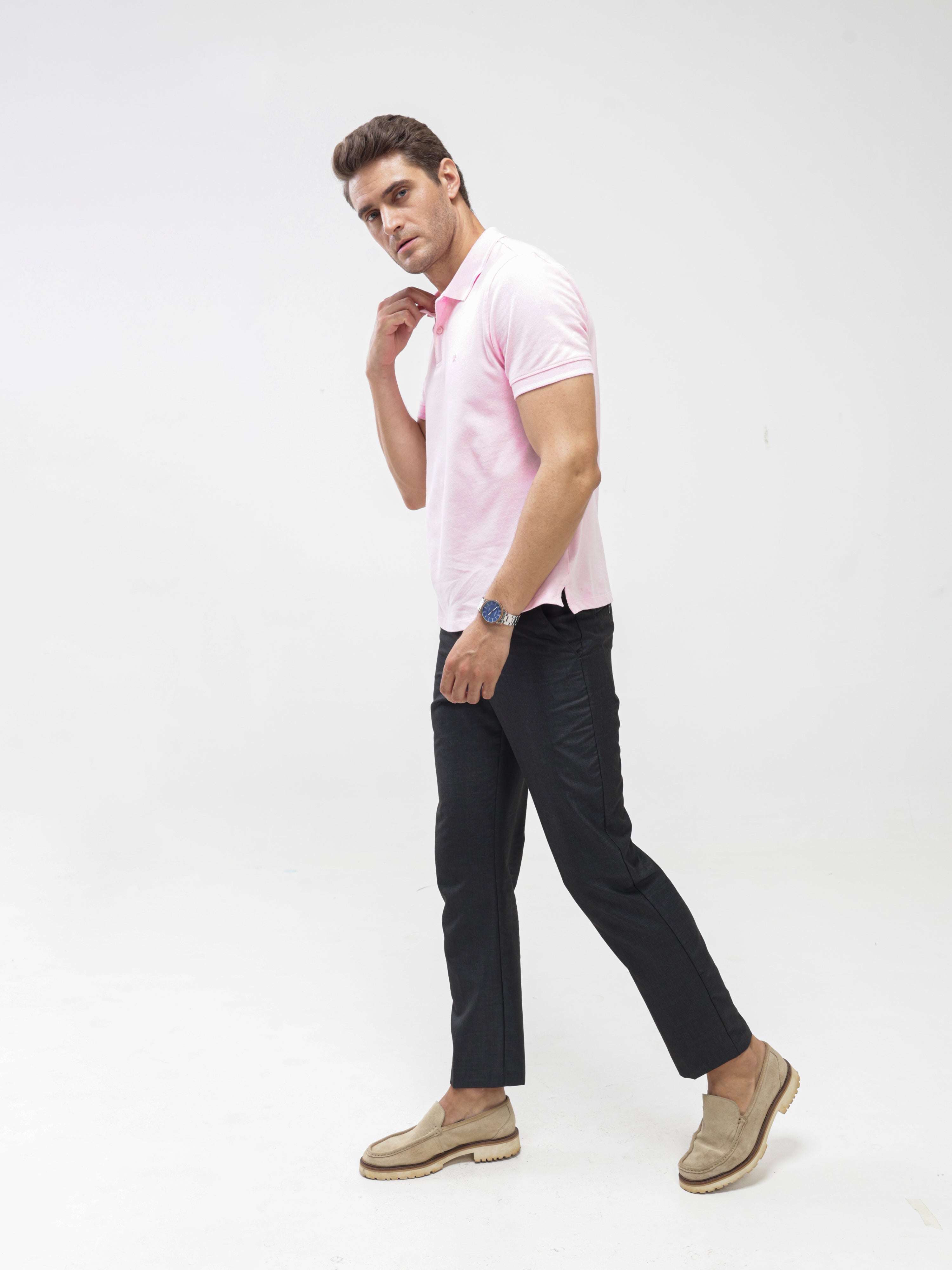 Man wearing a light pink Turms Polo T-shirt and dark pants, showcasing tailored fit and premium cotton fabric.