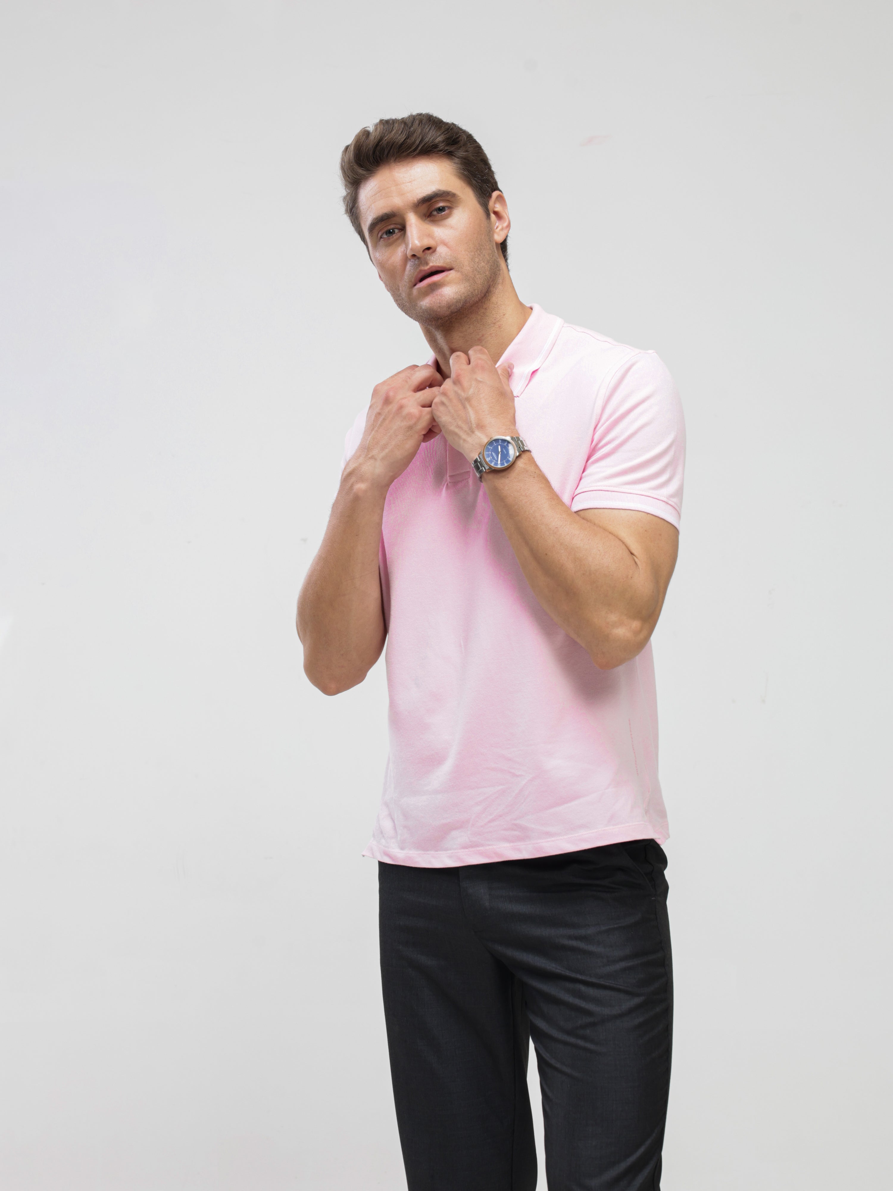 Man wearing a pink Turms polo tshirt made of premium cotton and spandex, showcasing tailored fit and anti-stain, water-resistant features.