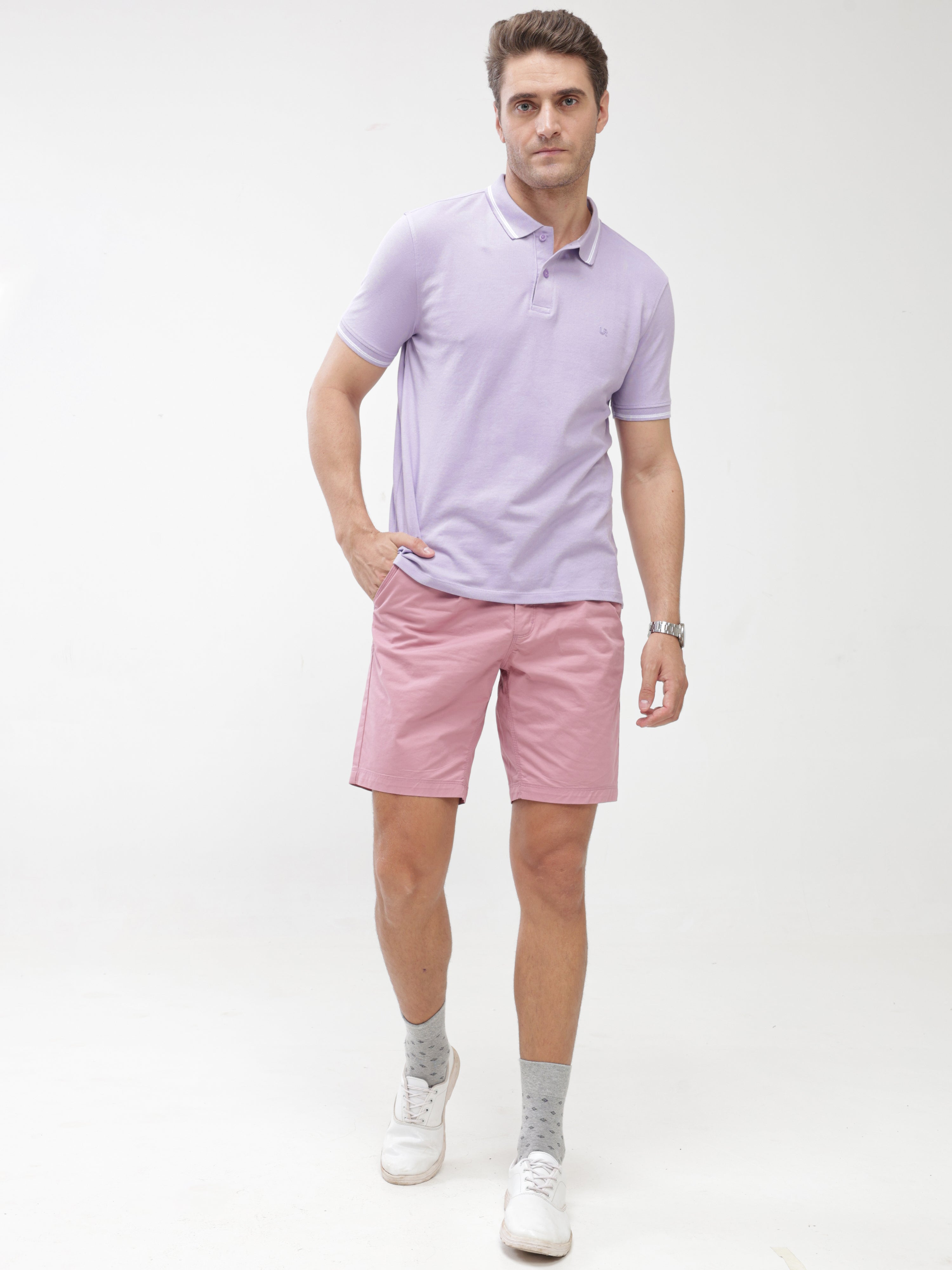 Man wearing Plume stain-proof and odor-resistant Turms Polo T-shirt in lavender, paired with pink shorts and white sneakers
