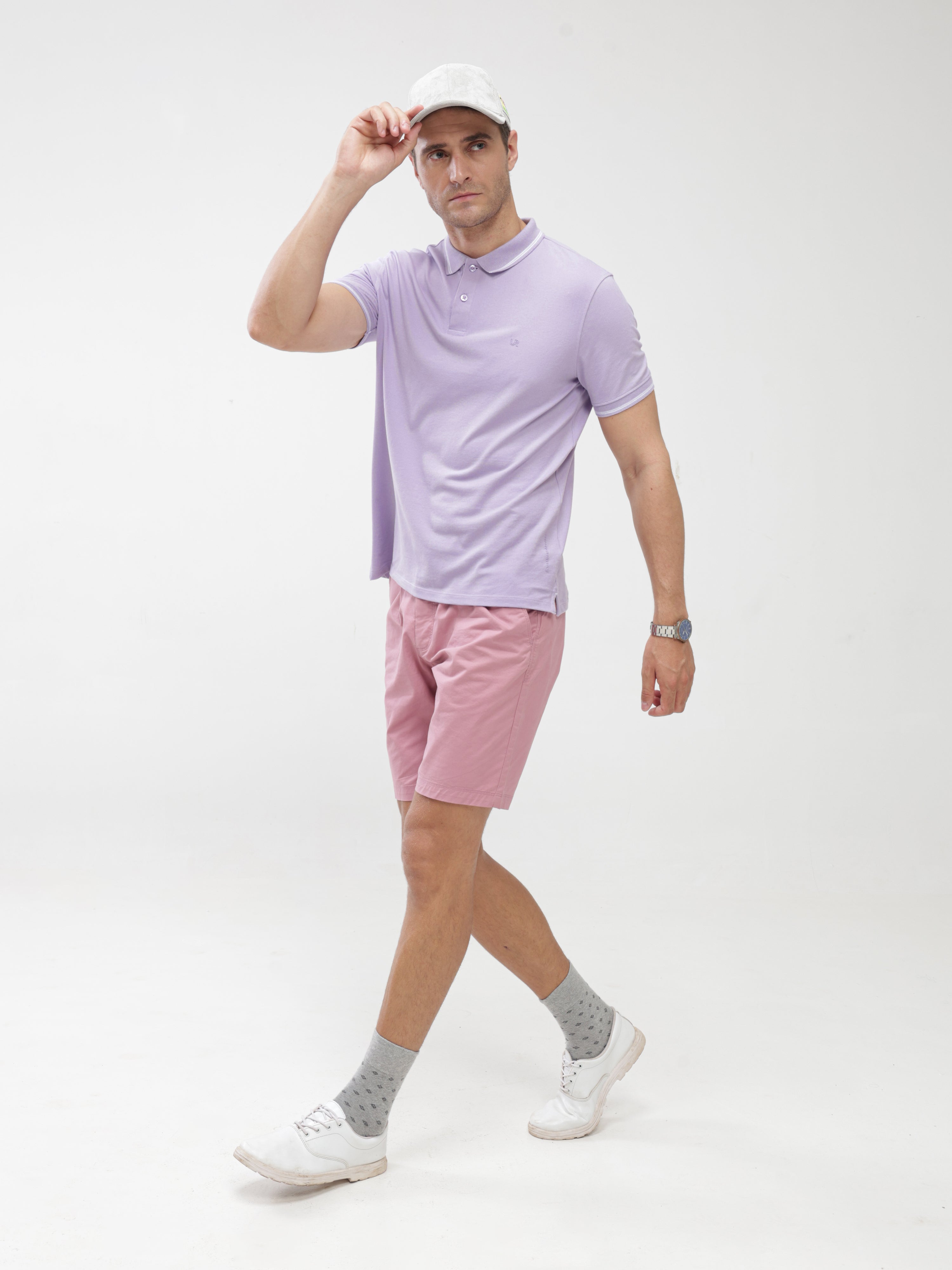 Man wearing lavender Polo tshirt and pink shorts, showcasing Turms stain-proof and odor-resistant menswear, best polo tshirt with premium cotton fabric