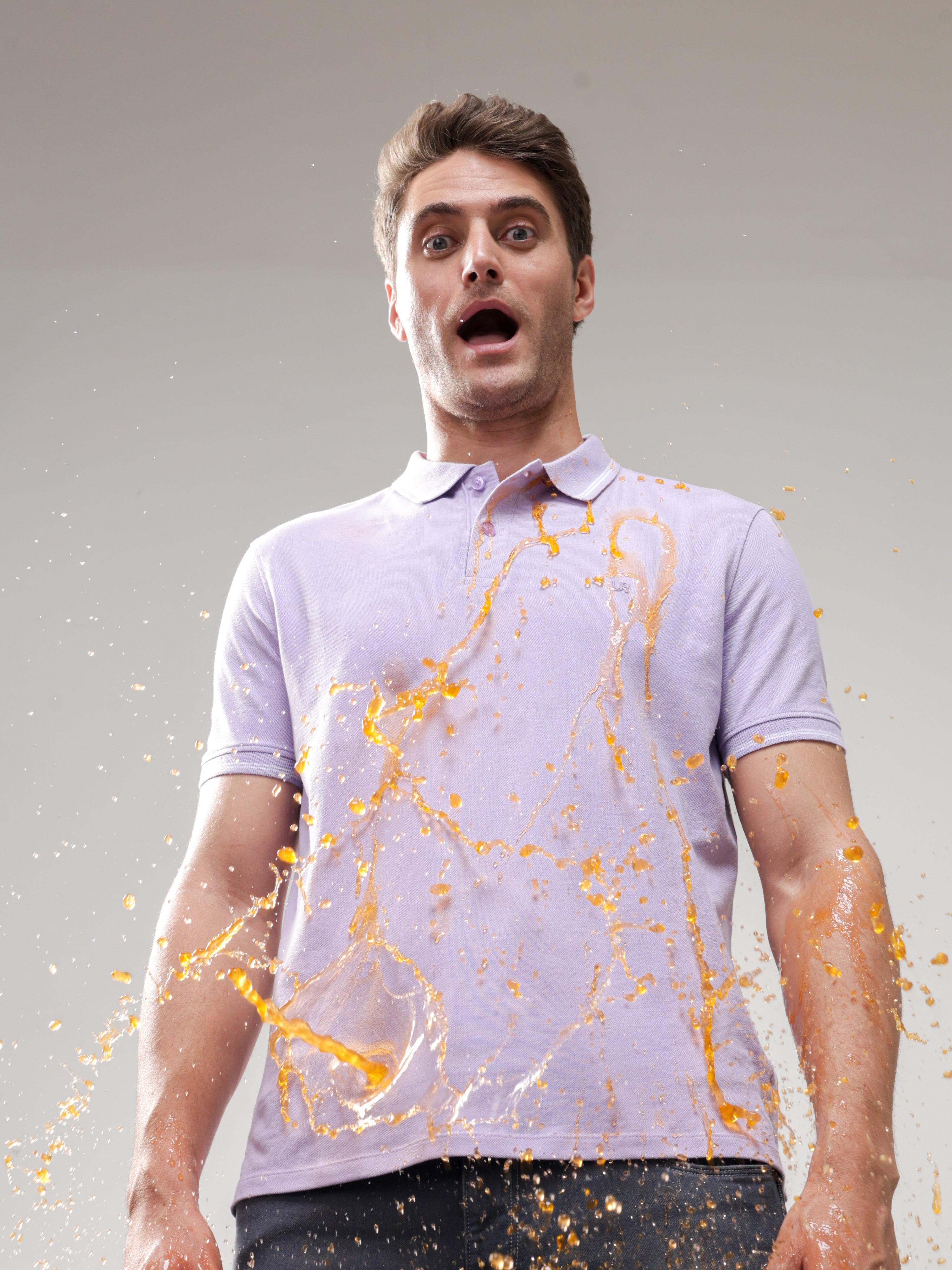 Man wearing stain-repellent Turms Polo T-shirt with liquid spill, showcasing best polo t-shirt for men, water-resistant, anti-stain menswear.