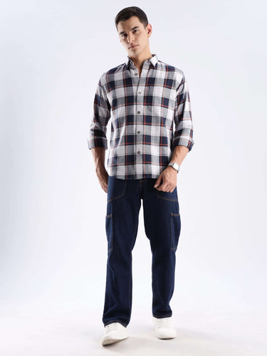 Model wearing a Blue Matrix checked shirt made from recycled cotton, paired with dark jeans in a stylish pose.