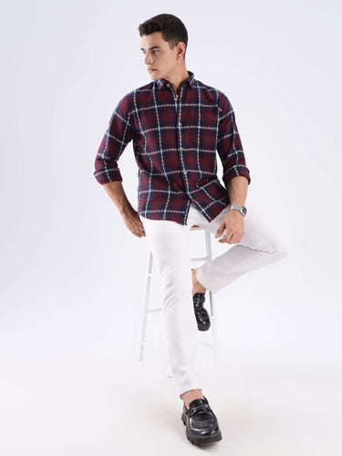 Man wearing a checkered recycled cotton shirt with white pants, showcasing sustainable fashion and style.
