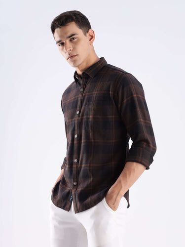 Man wearing a rustic plaid shirt made from recycled cotton, showcasing sustainable style and functionality.