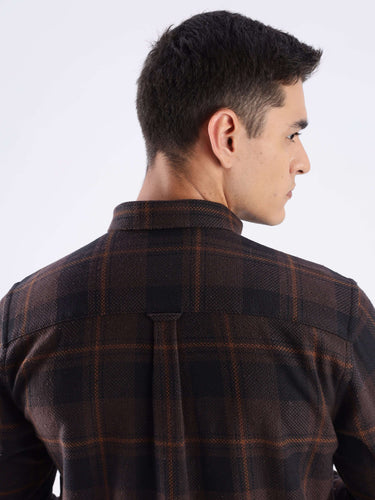 Back view of a man wearing a rustic recycled cotton checked shirt, showcasing quality stitching and stylish design.