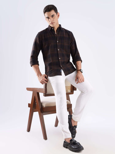 Model wearing a rustic recycled cotton check shirt with white pants, showcasing sustainable fashion and modern style.