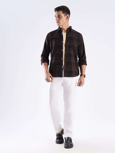 Man wearing a Rustic Nightshade recycled cotton checked shirt with stylish white pants.