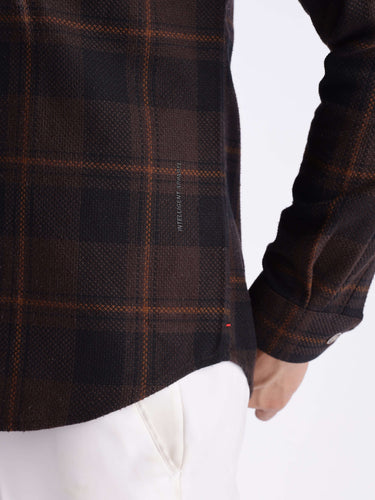 Close-up of a man wearing a dark checked recycled cotton shirt showcasing its durability and style.