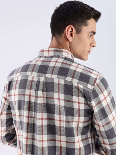 Rear view of a man wearing a grey checked shirt made from sustainable recycled cotton, showcasing its quality and design.